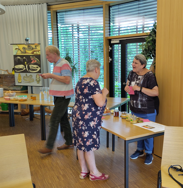 Station "die unverdrossenen bienenschar": Menschen, die Honig testen und ins Gespäch kommen.