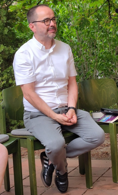 Musikalischer Reisesegen: Dirk Rothmann sitzt auf einem Stuhl auf der Terrasse der Deutschhauskirche