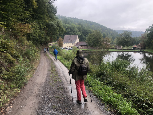 Weg mit Wanderern zur Kartause Grünau im Spessart.