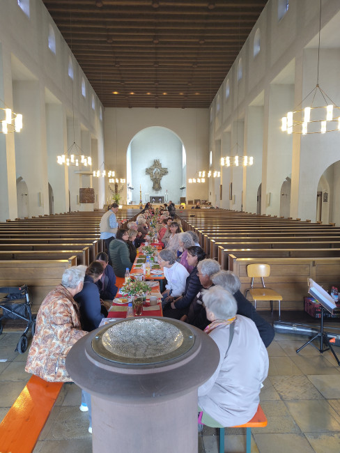 Kaffeetafel mit Biertischen durch den langen Mittelgang der Heiligkreuz-Kirche in Würzburg 