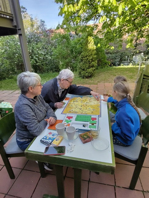 4 Spieler:innen beim Spielen von "Deutschlandreise".