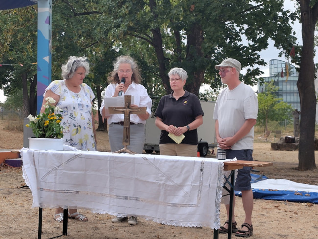 Abendgottesdienst bei der Umweltstation: Vier Personen lesen am Altar die Schöpfungsgeschichte in 7 Tagen.