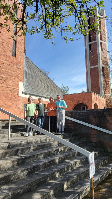 vier der sieben Helfer:innen, die den Vorplatzes der Erlöserkirche von Moos und Unkraut befreit haben, auf den Stufen vor der Erlöserkirche